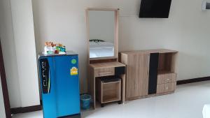 a room with a mirror and a refrigerator and a bed at The Wisdom Residence in Bung Kan