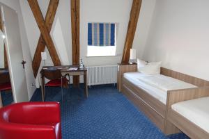 Schlafzimmer mit einem Bett, einem Schreibtisch und einem Stuhl in der Unterkunft Tagungshaus Schönenberg in Ellwangen