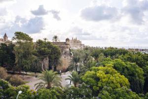 a castle on top of a hill with trees at Hotel Hostal Cuba in Palma de Mallorca