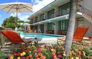 a hotel with a pool and chairs and an umbrella at Sea Cliff Hotel in Fort Lauderdale