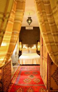 1 dormitorio con cama y alfombra roja en Riad Djemanna en Marrakech