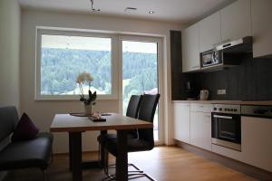 uma cozinha com mesa e cadeiras e uma janela em Appart Stefanie em Sankt Gallenkirch