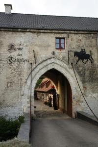 una entrada a un edificio con una vaca saltando sobre él en La Ferme des Templiers de Fléchinelle, en Enquin-les-Mines