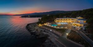 una vista aérea de un edificio sobre el agua por la noche en Fontana Resort en Jelsa