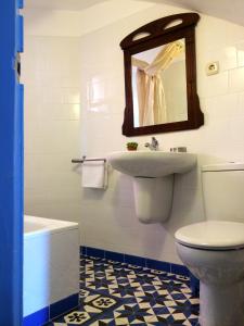 a bathroom with a sink and a toilet and a mirror at The Old Fisherman´s House in Villajoyosa