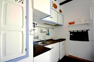 a small kitchen with white cabinets and a sink at The Old Fisherman´s House in Villajoyosa
