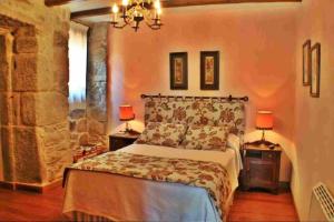 a bedroom with a bed and two lamps on tables at Casa Combarro in Combarro