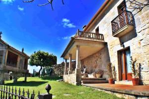 a stone house with a balcony and a fence at Casa Combarro in Combarro