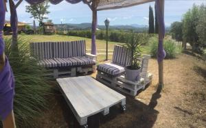 2 sedie e un tavolo da picnic sotto un gazebo di Agriturismo Il Poggio Di Orvieto a Orvieto