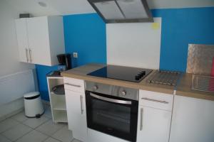 a kitchen with blue walls and a stove top oven at L'annexe in Étaples