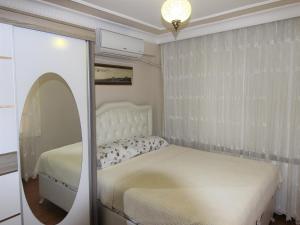 a white bedroom with a bed and a mirror at Sultanahmet Deluxe Yilmaz Apart in Istanbul