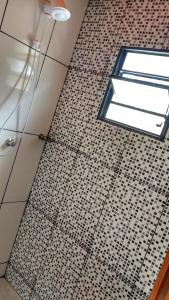 a bathroom with a tile floor and a window at Chalé Primavera - Eubiose in São Thomé das Letras