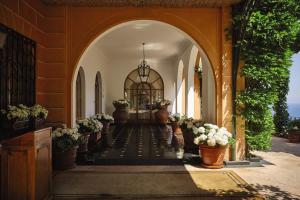 an entry to a building with potted plants and an archway at Splendido, A Belmond Hotel, Portofino in Portofino