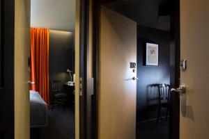 una puerta abierta a una habitación con dormitorio en Hotel Le Chat Noir, en París
