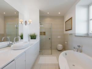 a white bathroom with two sinks and a tub and a shower at Loretańska Apartments 6 in Krakow