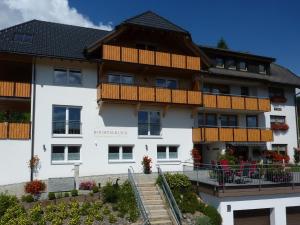 un gran edificio blanco con balcones de madera en Hochtalblick, en Bernau im Schwarzwald