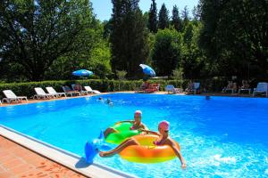 zwei Personen spielen in einem Pool mit aufblasbarem in der Unterkunft Camping Siena Colleverde in Siena