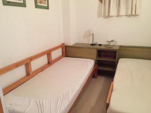 ロザスにあるBertur Port Canigóのベッド2台、デスクが備わる小さな客室です。