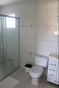 a white toilet sitting in a bathroom next to a sink at Pousada Caminho das Ilhas in Pontal do Paraná