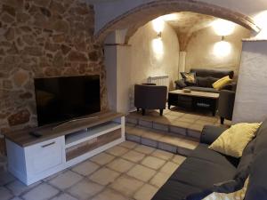 uma sala de estar com um sofá e uma televisão de ecrã plano em Casa Murada em Tivissa