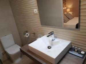 a bathroom with a sink and a toilet and a mirror at Casa Murada in Tivissa