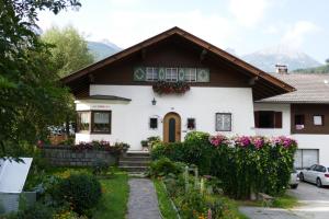 ein Haus mit Blumen davor in der Unterkunft Ferienwohnungen Schnarf in Olang