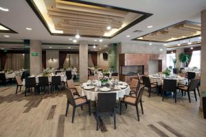 a dining room with tables and chairs in a restaurant at Hotel Etropolia in Etropole