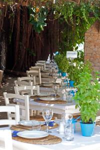 a long table with white chairs and wine glasses at Sandy Beach Hotel & Spa - ex Sentido in Larnaca