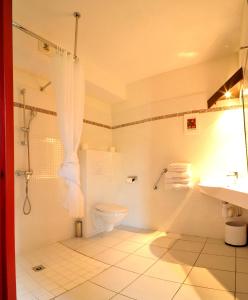 a bathroom with a shower and a toilet and a sink at The Originals City, Hotel Novella Confort, Nantes Est in Carquefou +9 photos