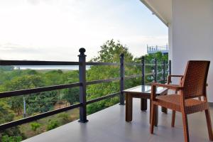 a dining room table with chairs and a balcony at Centauria Wild in Udawalawe