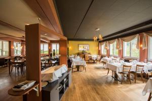 een eetkamer met witte tafels en stoelen bij Hotel Restaurant Neuhaus in Hertenstein