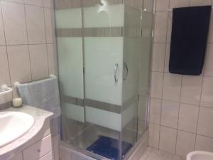 una ducha con una puerta de cristal junto a un lavabo en Cantinho Solpraia, en Porto Santo 16 fotos más