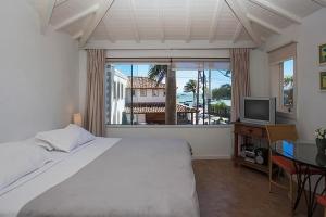 a bedroom with a bed and a television and a window at Passeio das Palmeiras in Búzios