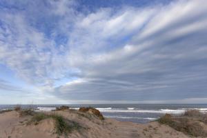 una playa de arena con un cielo nublado y el océano en Comtessa, en Oliva