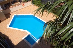 an overhead view of a blue swimming pool at Lets Holidays Palmera III in Tossa de Mar