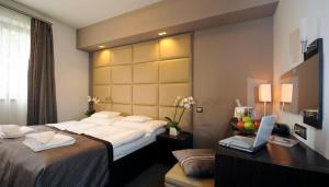 A bed or beds in a room at Hotel Villa Völgy Wellness & Konferencia