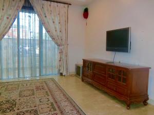 a living room with a television and a large window at Shuang Yang Sekinchan Homestay 6 in Sekincan