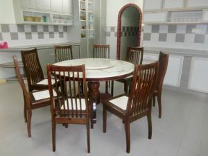 a dining room table with four chairs and a table and a mirror at Shuang Yang Sekinchan Homestay 6 in Sekincan
