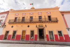 a building with a balcony and a flag on it at Hotel Casa Virreyes in Guanajuato