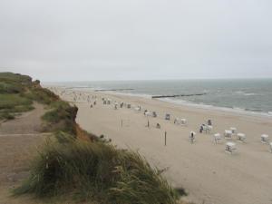 a beach with a bunch of chairs and the ocean at Haus Conwind in Keitum