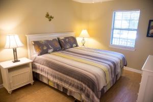 a bedroom with a bed and two lamps and a window at Pawleys Island Vacation Rentals llc in True Blue