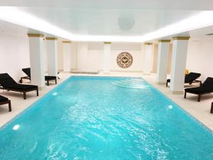 una piscina en una habitación con sillas y mesa en Theoxenia Palace, en Atenas