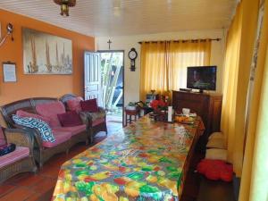 Pousada Porto Guará في غواراتوبا: غرفة معيشة مع أريكة وطاولة