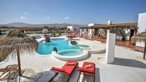 a resort with a swimming pool with chairs and umbrellas at Villa la senda del majorero in Antigua