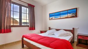 ein Schlafzimmer mit einem Bett mit einer roten Decke darauf in der Unterkunft Villa la senda del majorero in Antigua + 30 Fotos