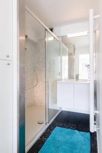 a bathroom with a shower and a blue rug at Sea View Apartment Knokke in Knokke-Heist