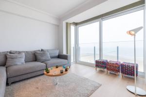 a living room with a couch and a large window at Sea View Apartment Knokke in Knokke-Heist