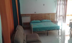 1 dormitorio con 1 cama con almohadas azules y 2 sillas en Villa Rustica, en Nardò
