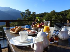 - une table avec de la nourriture et une corbeille de fruits dans l'établissement Maison d'Hôtes Zella, à Bains de Guitera