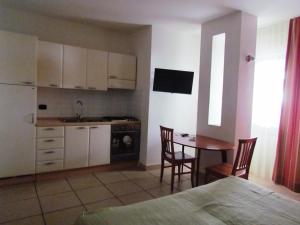 una cucina e una sala da pranzo con tavolo e sedie di Miramare Residence a Pozzuoli